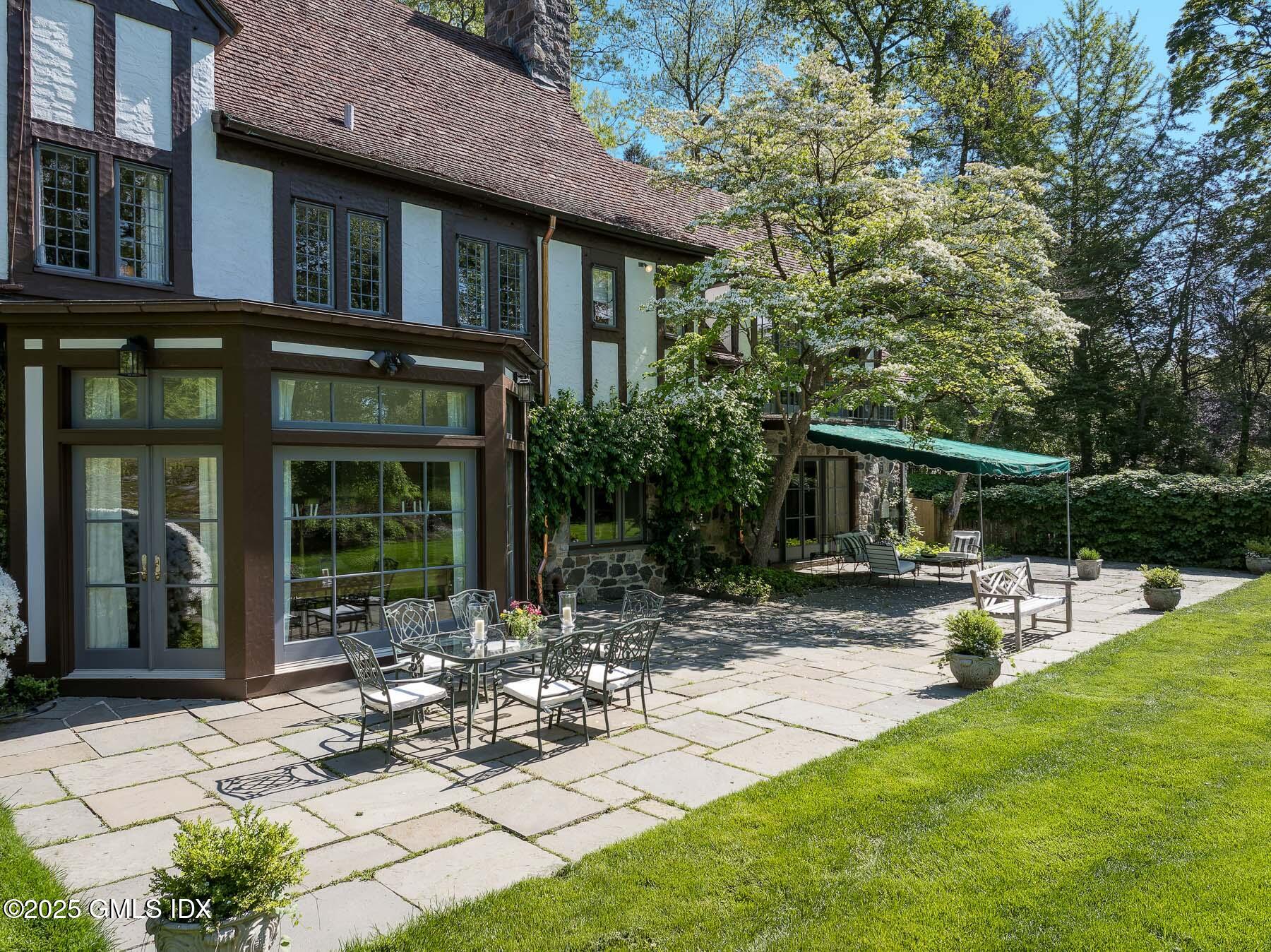 78 Khakum Wood Road Greenwich, CT 06831 - Photo 17 of 27 a view of a chair and table in backyard of the house