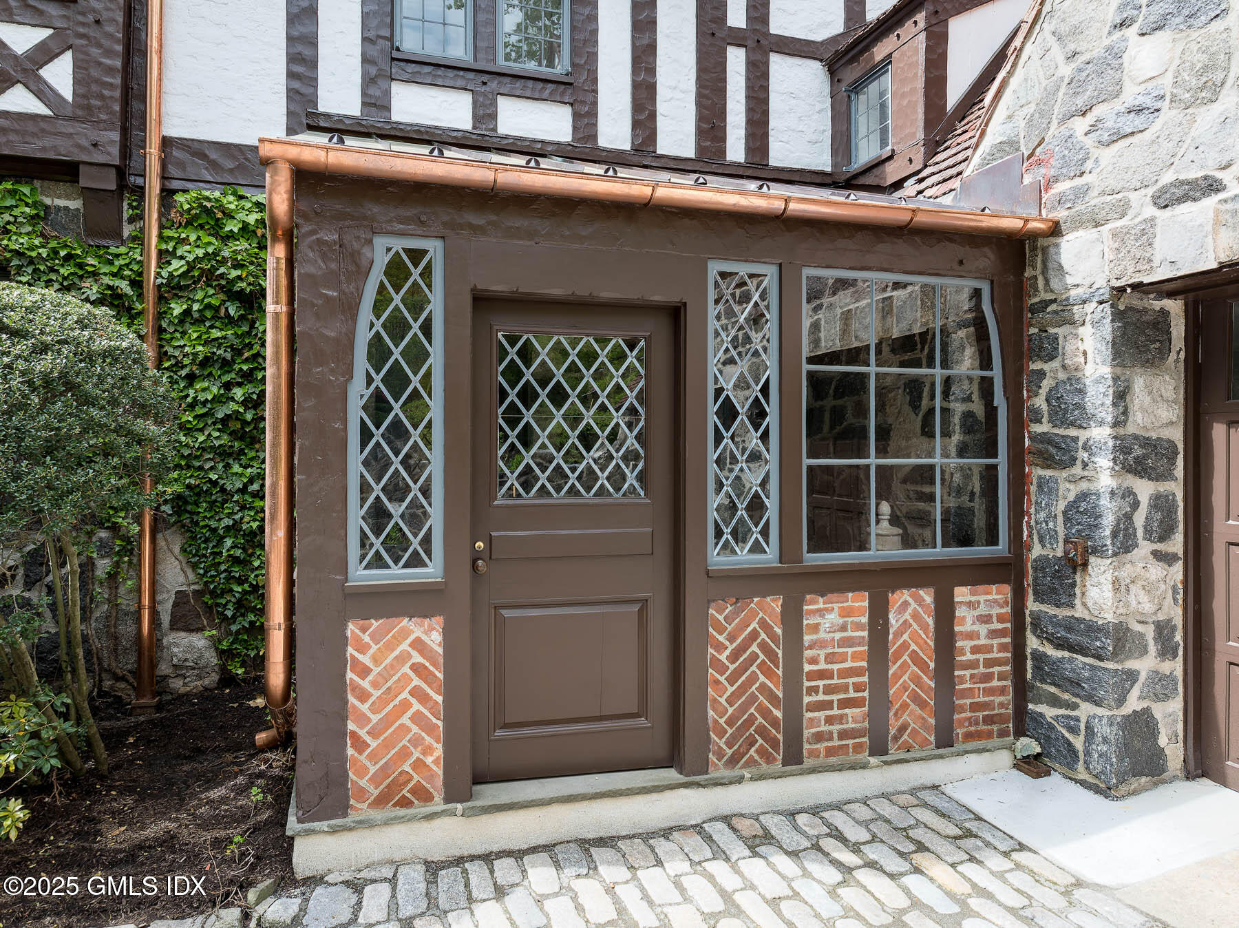 78 Khakum Wood Road Greenwich, CT 06831 - Photo 19 of 27 a front view of a building with a door and a yard