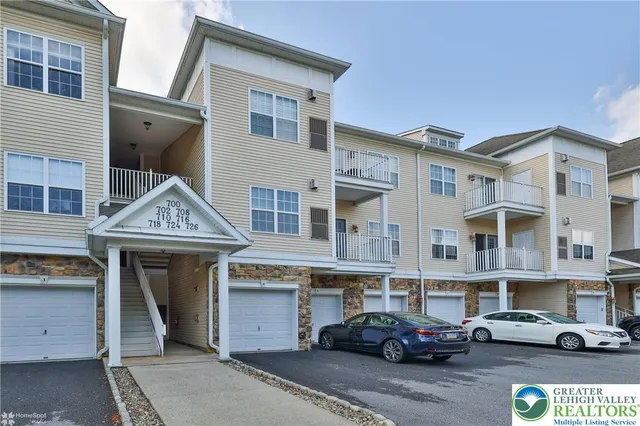 a front view of a residential apartment building with a car parked front of it