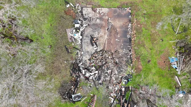a aerial view of a house with a yard and large trees