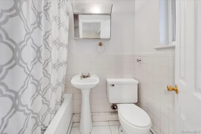 a white toilet sitting next to a shower