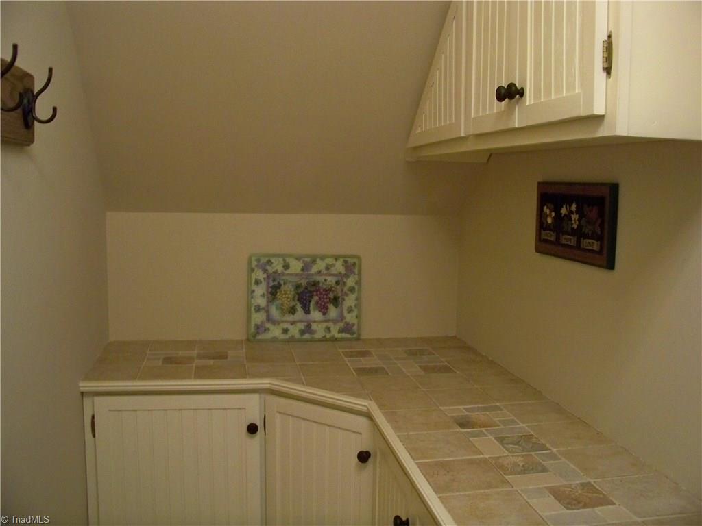 5805 Autumn Gate Drive Oak Ridge, NC 27310 - Photo 16 of 30 The area under the stairs has been transformed into an ingenious and practical storage area!