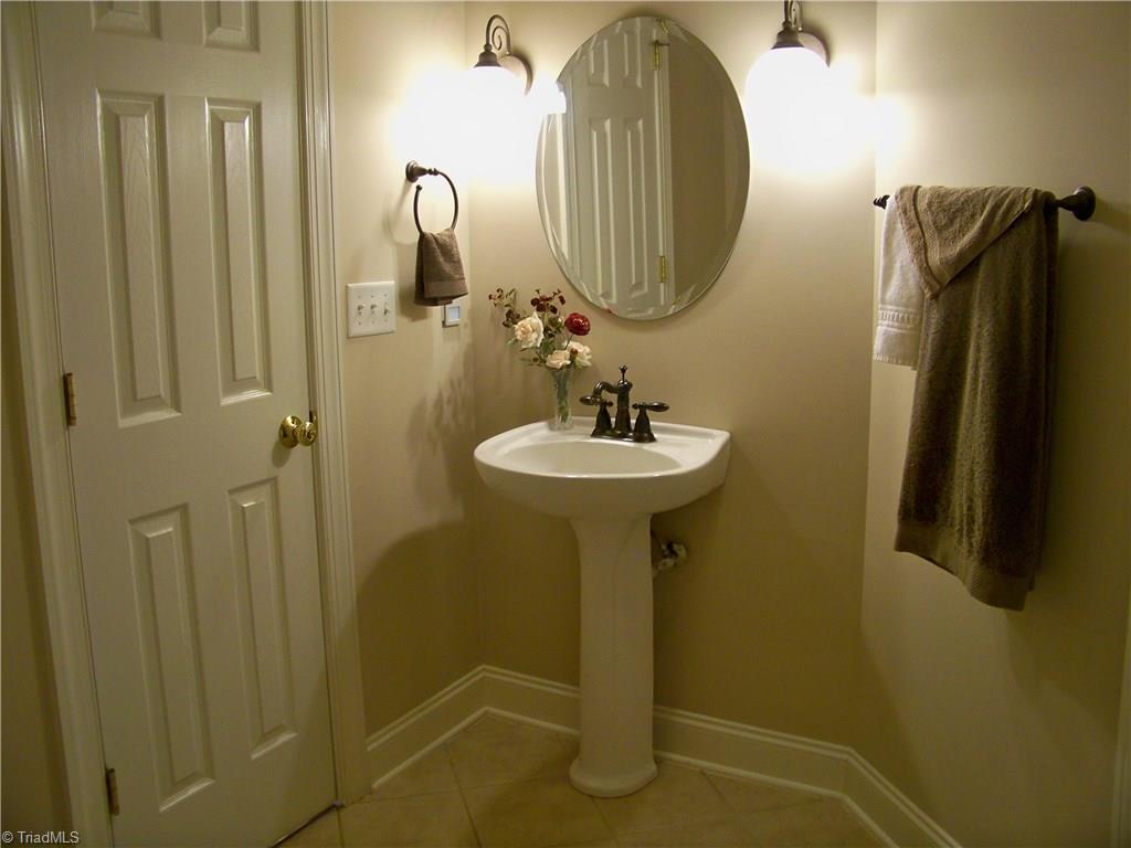 5805 Autumn Gate Drive Oak Ridge, NC 27310 - Photo 26 of 30 The full bath on main level serves as a powder room for guests via the door on the left of sink and also services the bedroom/study from a door not seen on right.