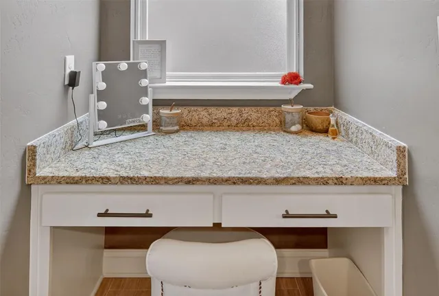 a bathroom with a granite countertop toilet sink and mirror