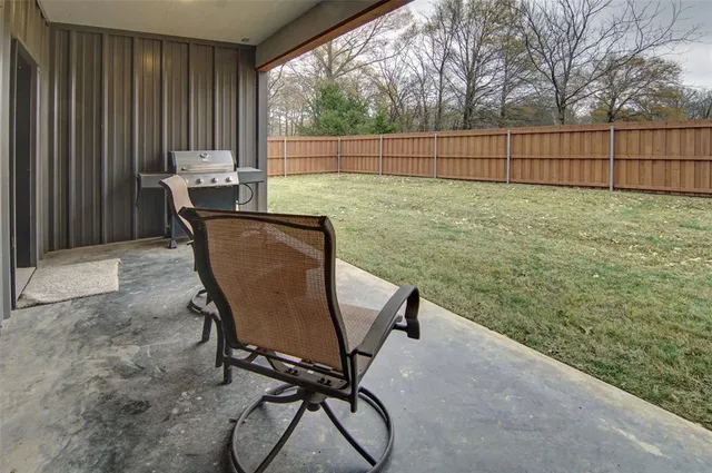 a view of a house with a yard and wooden fence