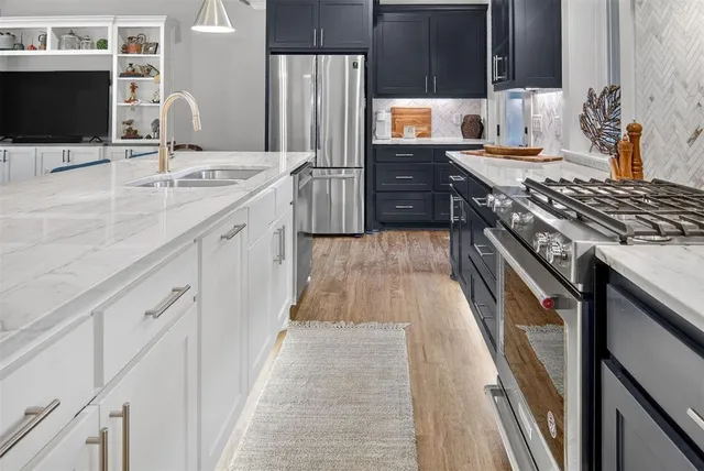 a kitchen with stainless steel appliances granite countertop a stove and a microwave