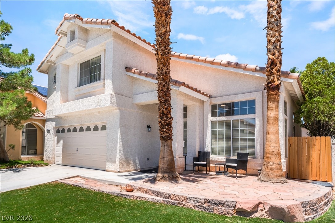 8872 Chapman Point Las Vegas, NV 89129 - Photo 2 of 29 White stucco facade with terracotta roof tiles welcomes you home to a front yard patio.