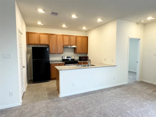 a kitchen with refrigerator and a sink