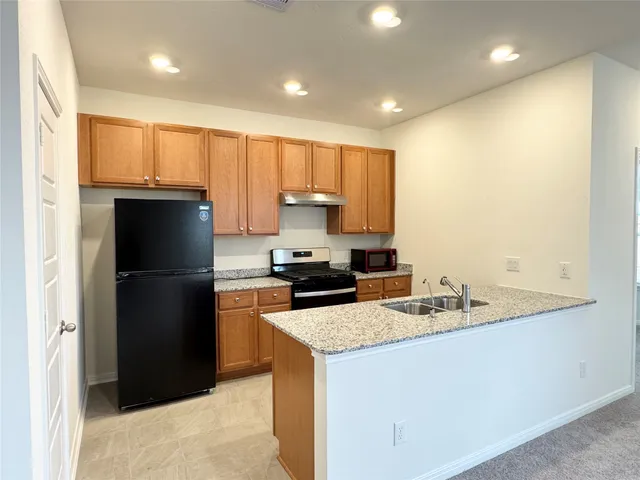 a kitchen with a refrigerator sink and cabinets