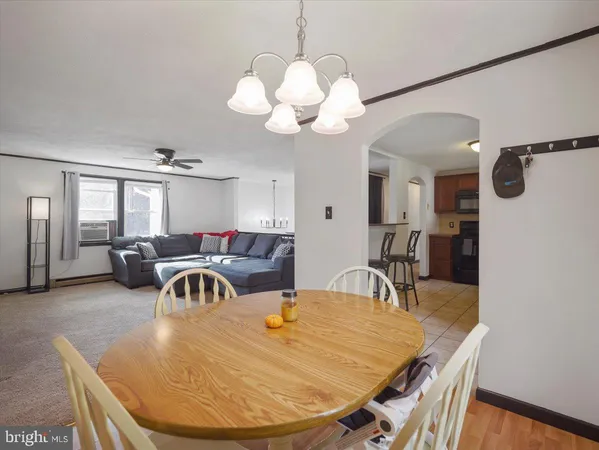 a dining room with wooden floor a chandelier a wooden table and chairs