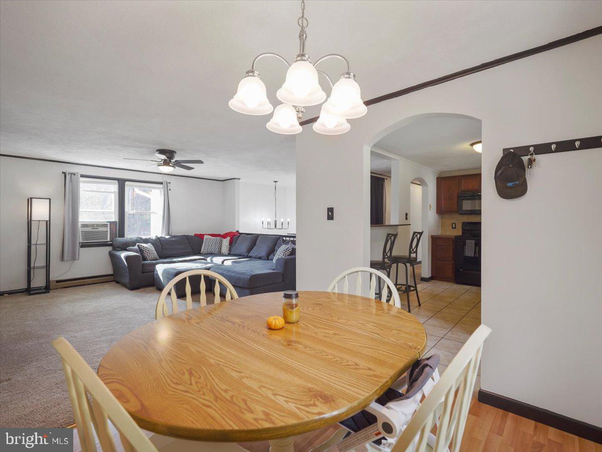 2731 Jack Road Chambersburg, PA 17202 - Photo 12 of 29 a dining room with wooden floor a chandelier a wooden table and chairs