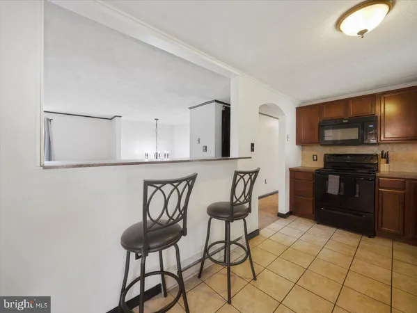 a kitchen with stainless steel appliances kitchen island granite countertop a stove a sink and a refrigerator