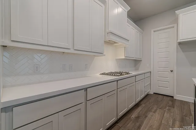 a kitchen with granite countertop white cabinets and white appliances