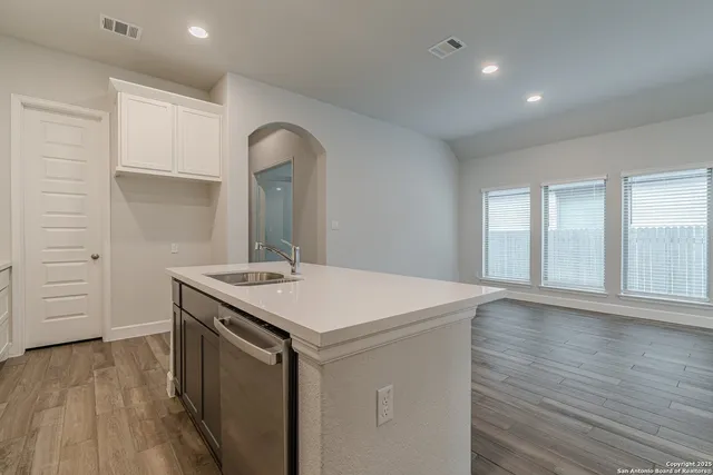 a kitchen with a stove and a wooden floor