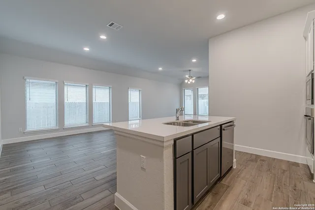 a kitchen with a sink and wooden floor