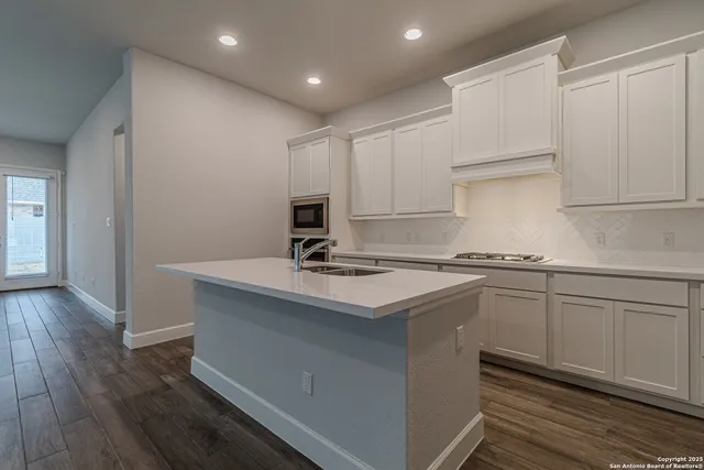 a kitchen with a sink cabinets and wooden floor