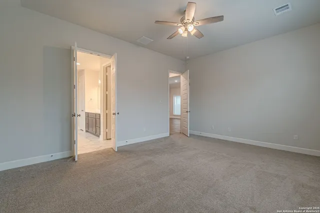 an empty room with chandelier fan