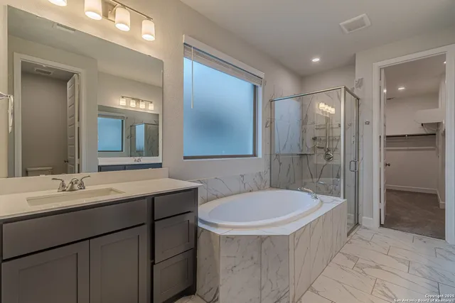 a bathroom with a sink a toilet a mirror and shower