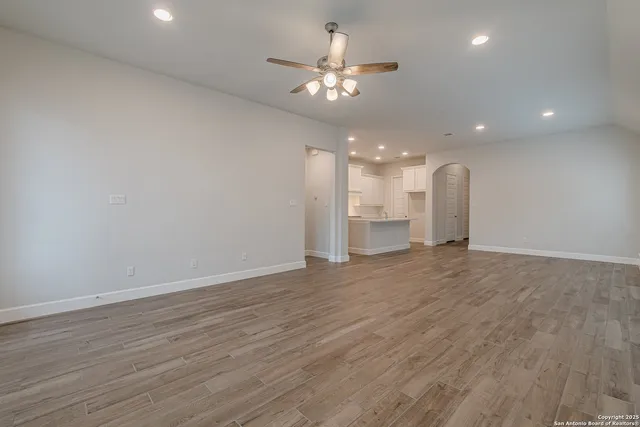 a view of an empty room and kitchen view