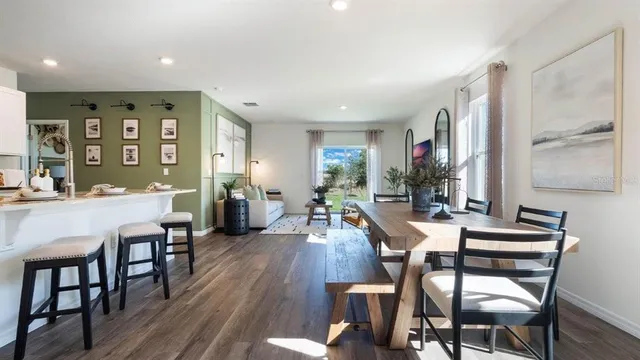 a view of a a dining room with furniture window and wooden floor