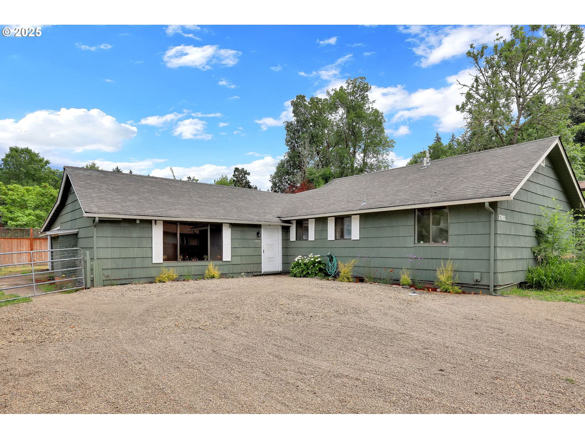 a front view of a house with a yard and potted plants
