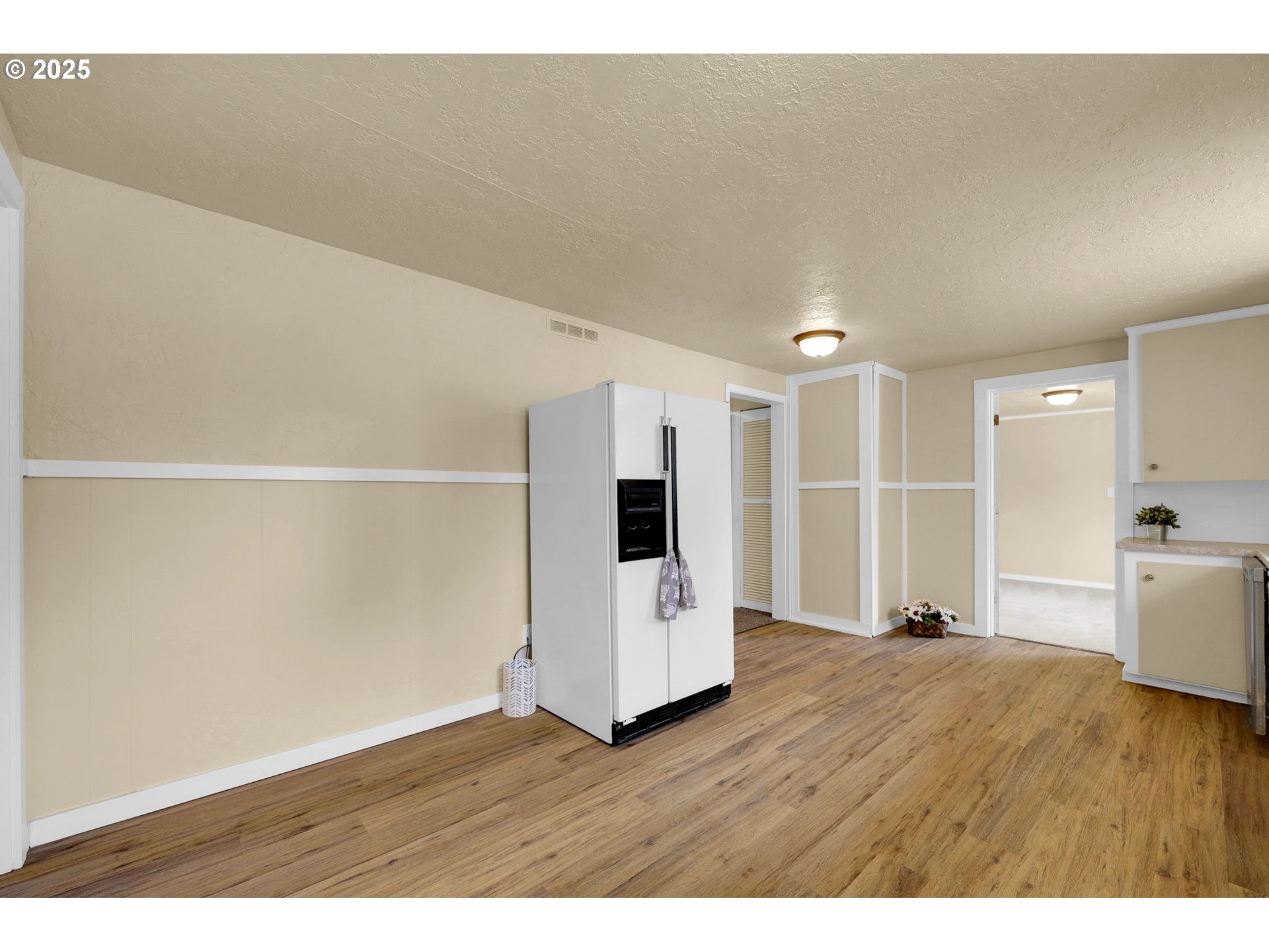 2785 Riverview Street Eugene, OR 97403 - Photo 12 of 44 a view of an empty room with wooden floor and kitchen