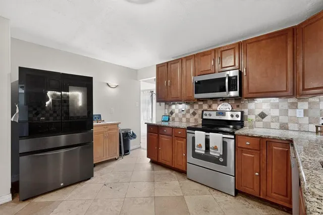 a kitchen with stainless steel appliances granite countertop a stove microwave and refrigerator