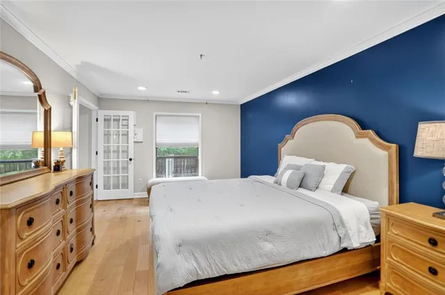 a bedroom with a large bed and a flat tv screen on dresser