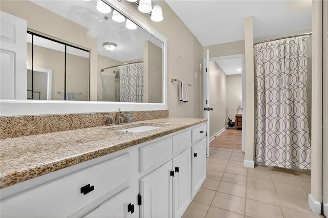 a spacious bathroom with a granite countertop sink mirror and shower