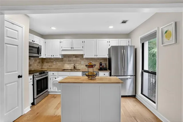 a kitchen with a refrigerator a stove top oven a sink and cabinets