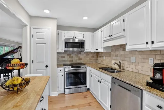 a kitchen with white cabinets and appliances
