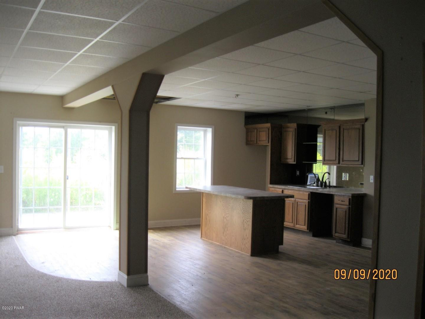 271 North Baker Road Waymart, PA 18472 - Photo 9 of 25 a view of a kitchen with kitchen island a sink wooden floor and a large window