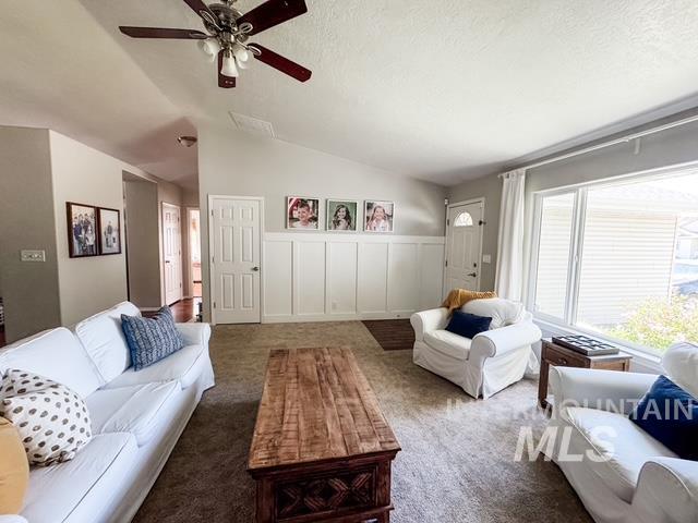 808 O'Leary Way Twin Falls, ID 83301 - Photo 4 of 37 Living area featuring vaulted ceilings, a ceiling fan with light fixture, a large window, and wainscoting paneling