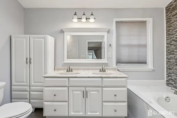 a bathroom with a sink vanity toilet and shower