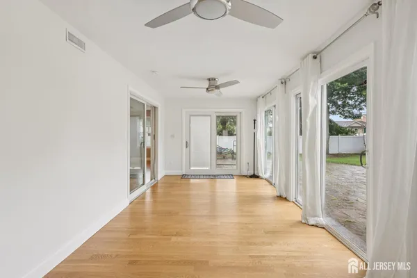 a view of a hallway with wooden floor and a window