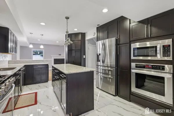 a kitchen with stainless steel appliances granite countertop a stove a refrigerator and a sink