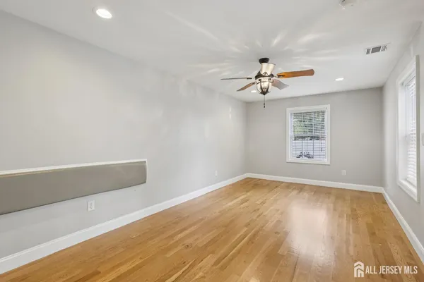 an empty room with a window and a ceiling fan