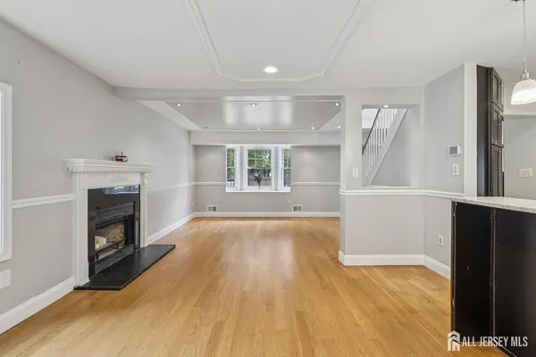 an empty room with windows and fireplace