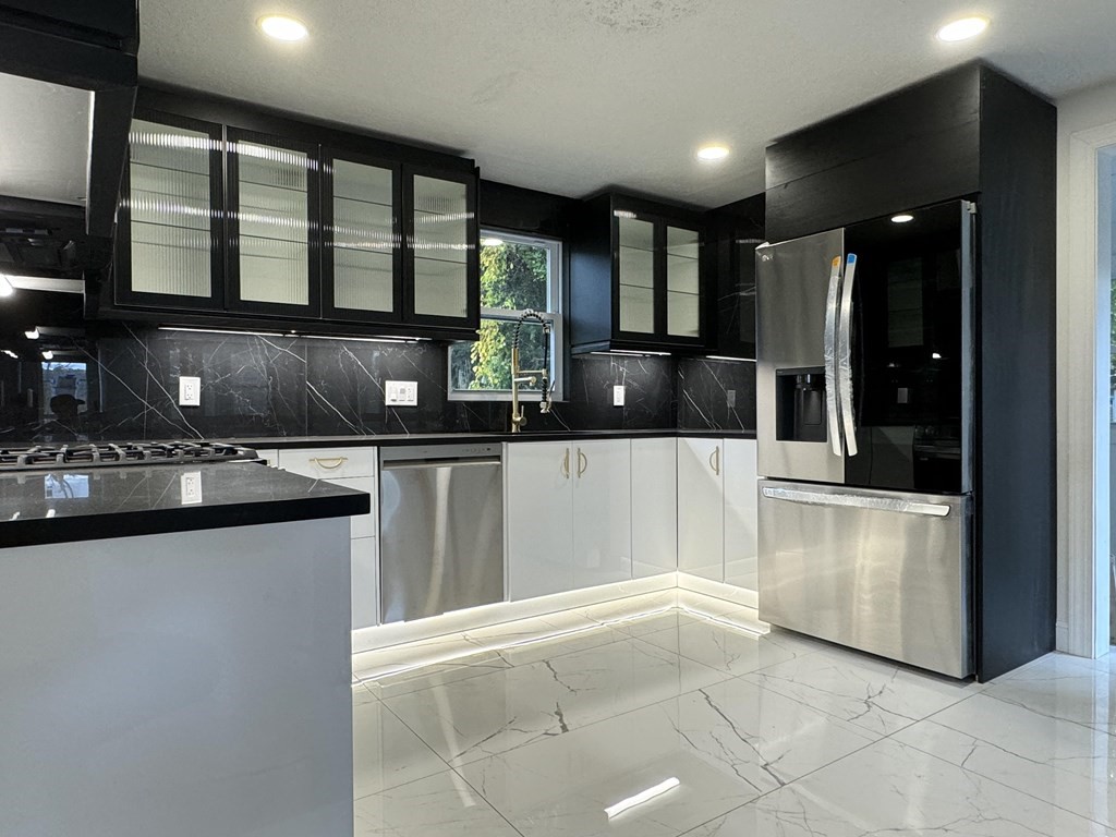 a kitchen with stainless steel appliances kitchen island granite countertop a sink and cabinets