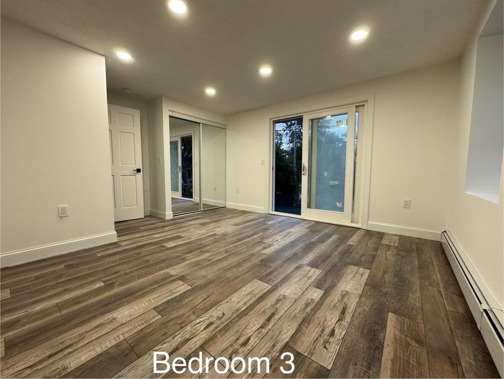 10 Proctor Street Worcester, MA 01606 - Photo 25 of 31 an empty room with wooden floor and windows