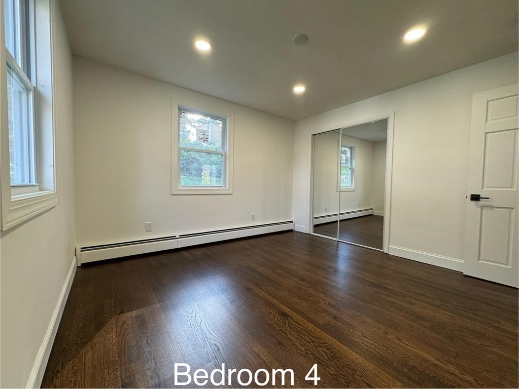 10 Proctor Street Worcester, MA 01606 - Photo 27 of 31 an empty room with wooden floor and windows