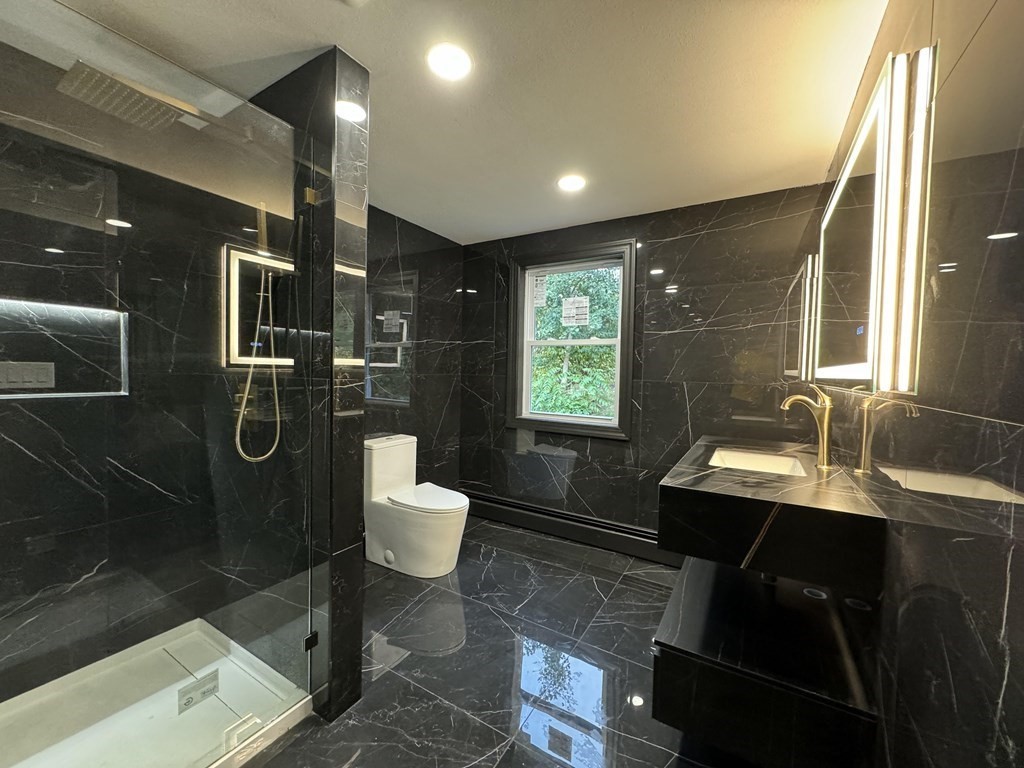 10 Proctor Street Worcester, MA 01606 - Photo 4 of 31 a bathroom with a sink toilet a mirror and tub