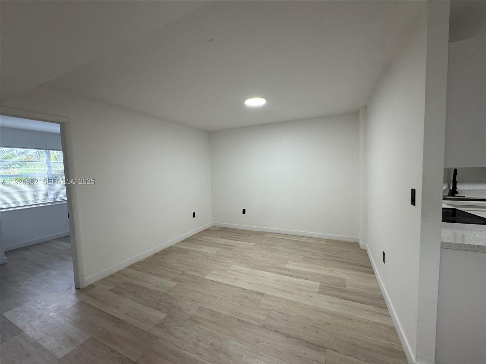 12215 West Dixie Highway, Unit 103 North Miami, FL 33161 - Photo 3 of 14 a view of an empty room and a window