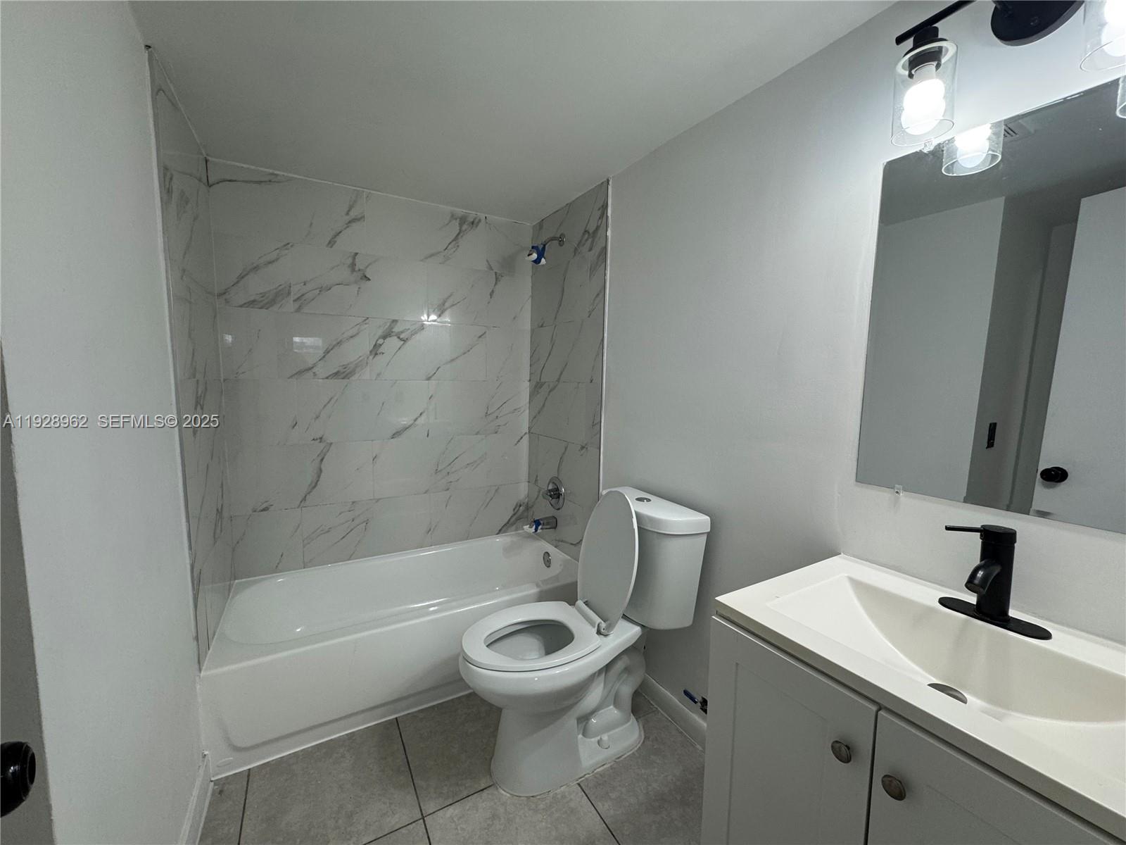 12215 West Dixie Highway, Unit 103 North Miami, FL 33161 - Photo 4 of 14 a bathroom with a sink a toilet and a bathtub