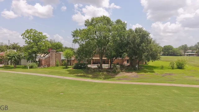 a view of a fountain in front of a house with a big yard