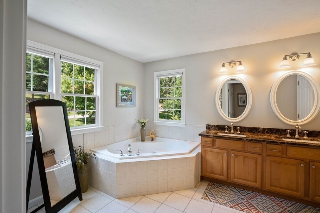 22 Falcon Ridge Drive Hopkinton, MA 01748 - Photo 26 of 42 a bathroom with a bathtub a mirror a sink and a window