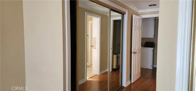 an empty room with wooden floor and entrance
