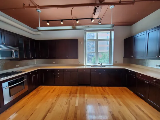 a kitchen with stainless steel appliances wooden cabinets a stove top oven and sink
