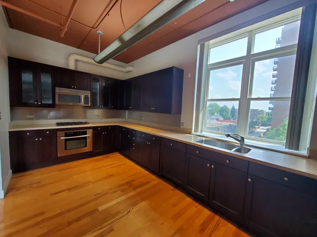 a kitchen with stainless steel appliances granite countertop a sink and large window