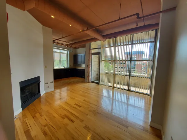 a view of an empty room with a fireplace and a window